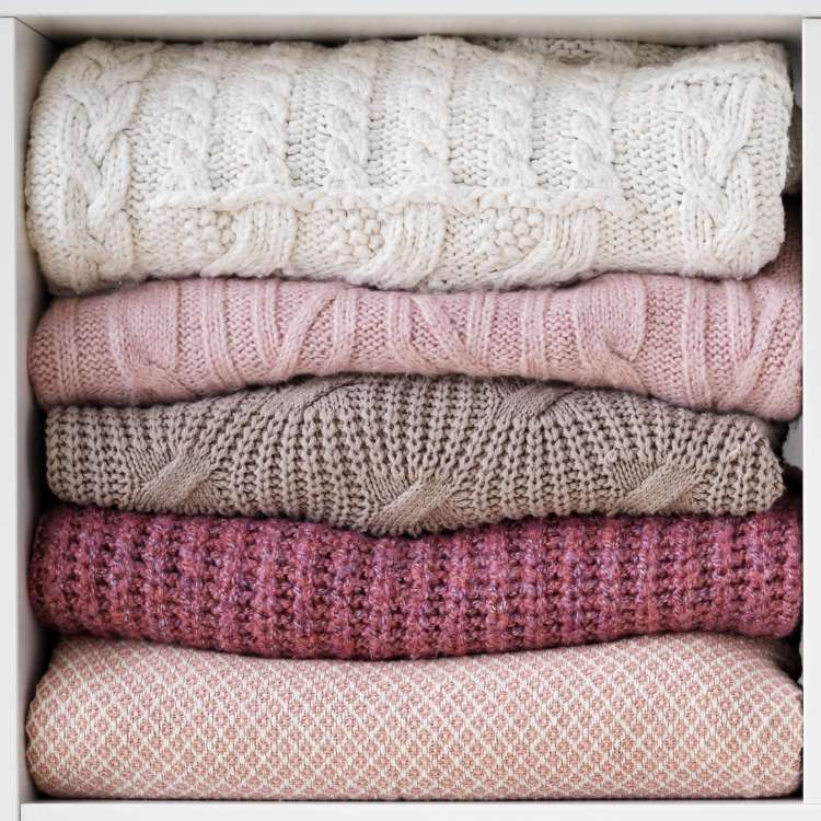 Three cozy and soft woolen scarves in a pile.